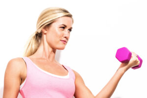 Happy young woman working out with dumbbell